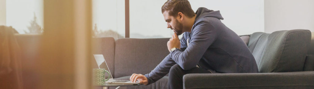 a person sat on a sofa using a laptop