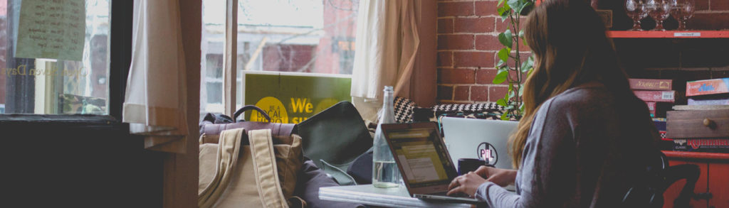 A person in a café looking at their laptop