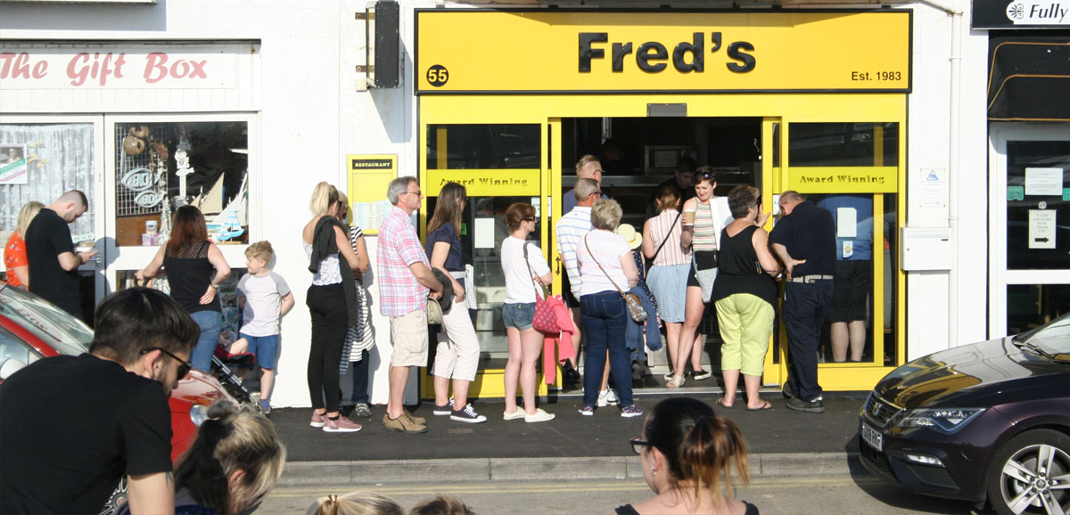 A que of people outside a fish and chip shop