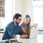 Two people reviewing a website on a laptop