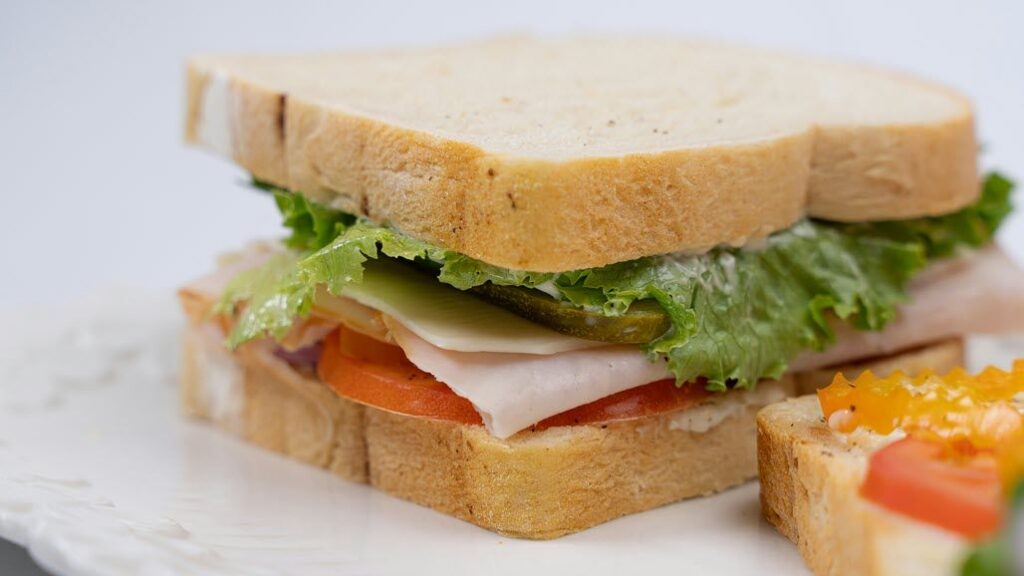 A photo of a ham salad sandwich in a white table top - by 05 Flims on Unsplash